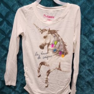 A white shirt with a picture of a unicorn on it.