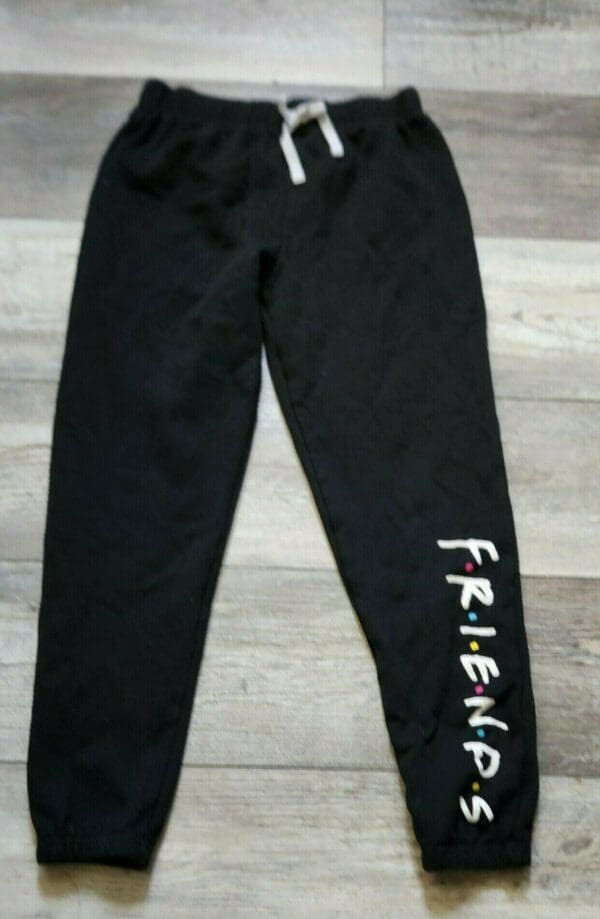 A pair of black sweatpants with the word " friends ".