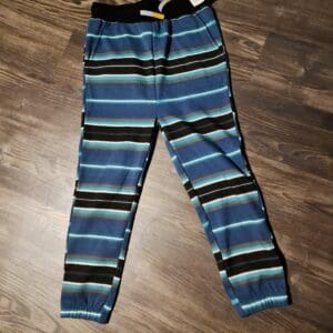 A pair of blue and black striped pants on the floor.