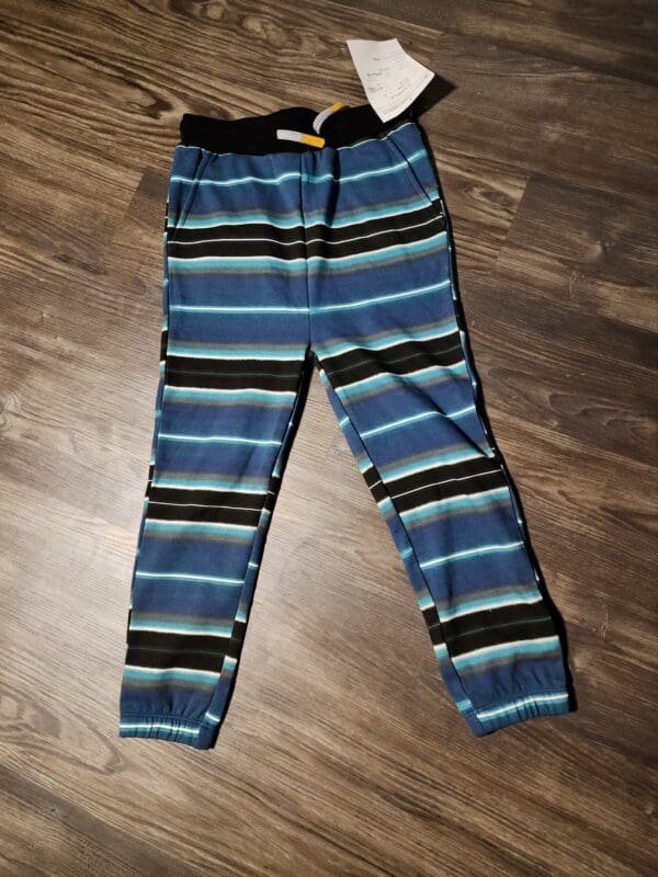 A pair of blue and black striped pants on the floor.