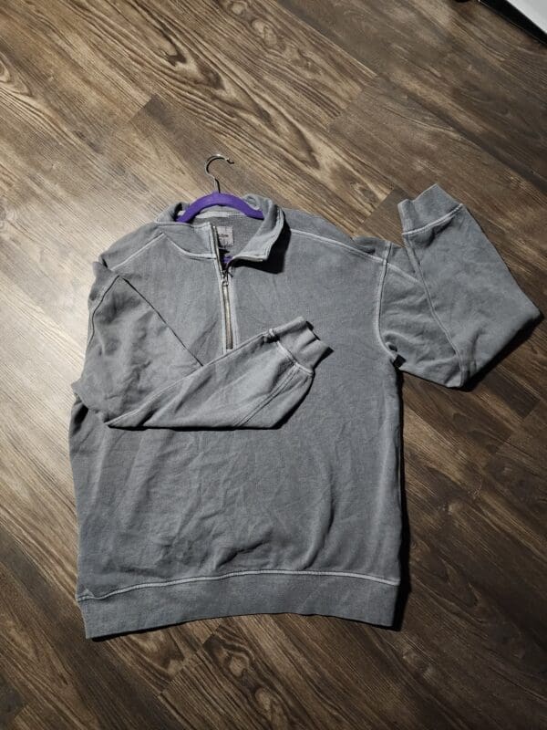 A gray sweatshirt hanging on the wall.