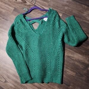 A green sweater hanging on the wall