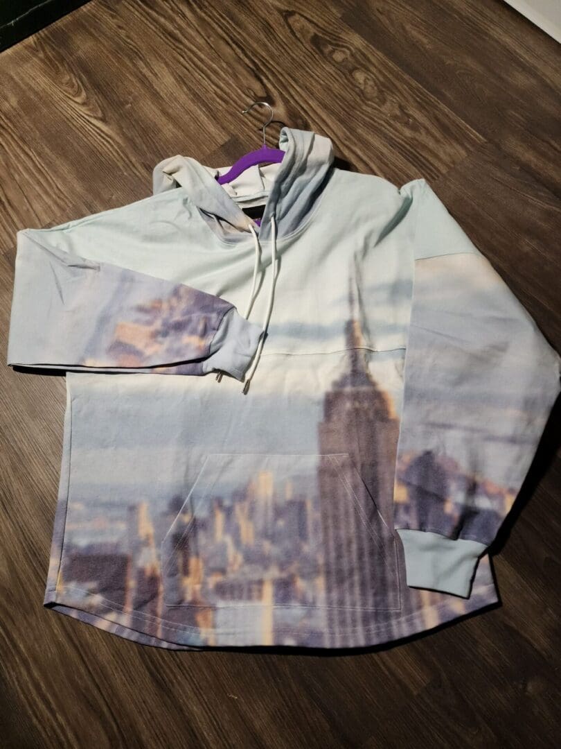 A shirt that is on the ground with pictures of buildings.