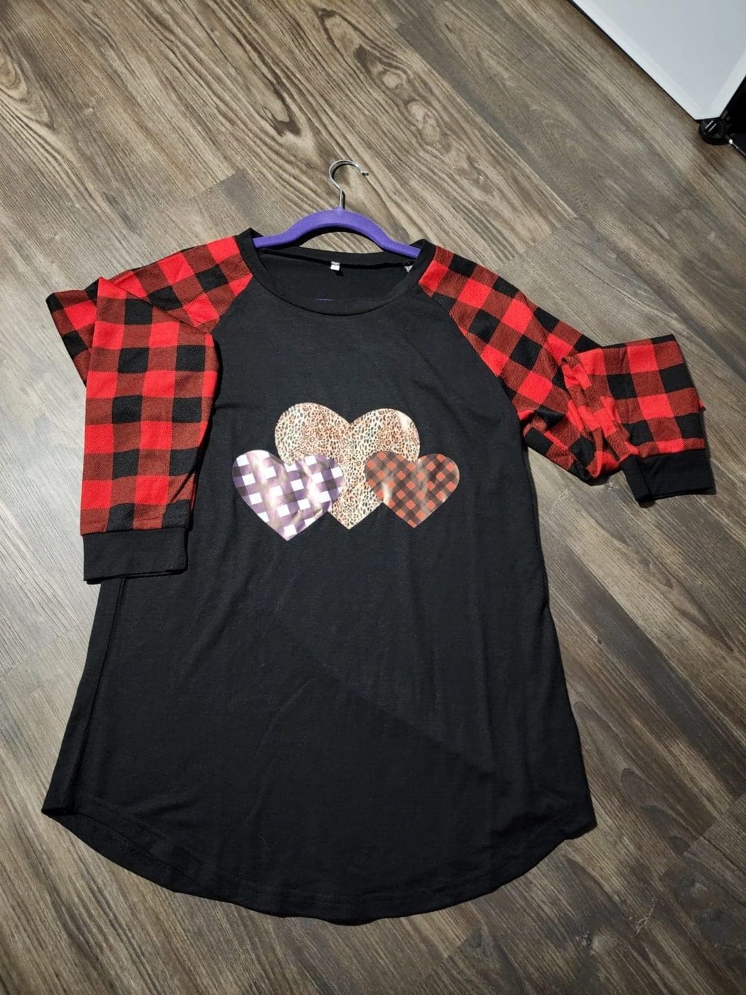 A black shirt with red and white plaid sleeves.